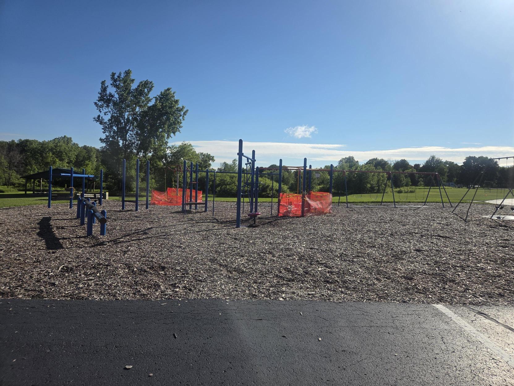 Current playground with orange safety fencing blocking off unsafe equipment